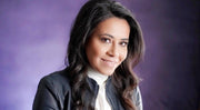 A woman with long, layered black hair smiles warmly, embodying health and wellness, reflecting WeNatal's focus on prenatal care and lifestyle products.